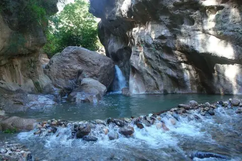 Un rincón idílico en las cascadas de Padules, Almería, donde el agua cristalina fluye entre rocas y vegetación exuberante.