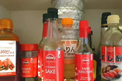 Szafka z azjatyckimi przyprawami: sosy, mirin seasoning, sake, sezam.