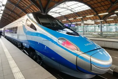 Nowoczesny pociąg Pendolino EIC z niebiesko-srebrnym malowaniem stoi na peronie.