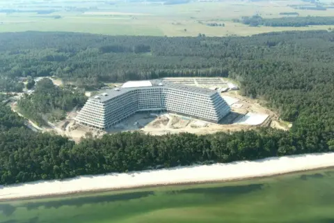 Budowa hotelu Gołębiewski w Pobierowie, widok z lotu ptaka na obiekt w otoczeniu lasu i plaży.