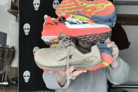 Trois paires de chaussures de trail colorées, empilées. Peut-on courir avec des chaussures de trail sur route ?