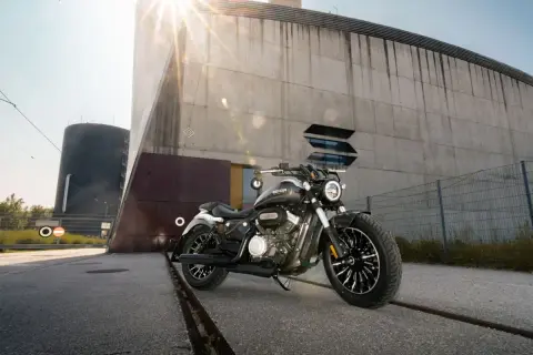 Czarny motocykl typu chopper 125 na tle nowoczesnego budynku.