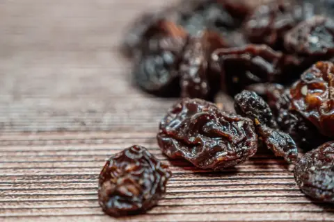Garść rodzynek na drewnianym tle. Zastanawiasz się nad rodzynki kcal?