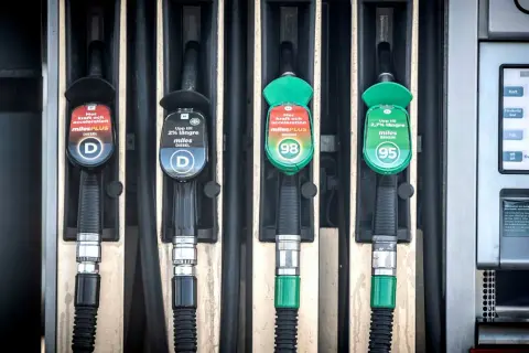 Fyra pumpar vid en bensinstation, två för diesel och två för bensin. En av dieselslangarna har en etikett som varnar för alger i dieseltank.