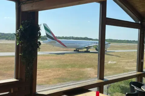 Ein Emirates-Flugzeug rollt auf dem Rollfeld. Perfekt für ein "Cafe to fly" mit Aussicht.