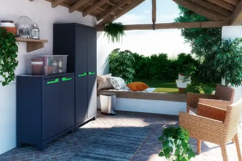 Ciemnoszara szafka na balkon z zielonymi uchwytami, idealna do przechowywania narzędzi ogrodowych i doniczek.
