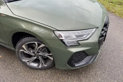 Zielony Audi A3 kombi z felgami S line na mokrej drodze.