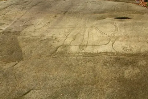 Grabados rupestres en el **campo lameiro**, con figuras de animales y círculos concéntricos, testigos de un pasado ancestral.