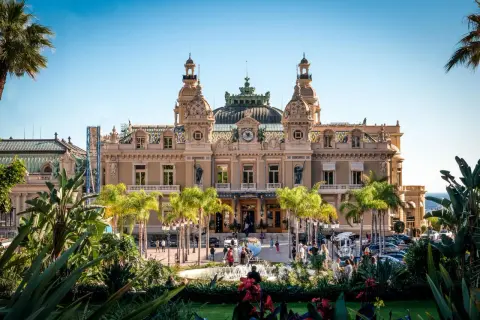 Kasyno Monte Carlo, symbol 2 najmniejszy kraj na świecie, otoczone palmami i bujną zielenią.