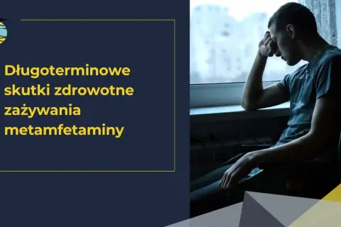 Młody mężczyzna siedzi przy oknie, pogrążony w myślach o długoterminowych skutkach zdrowotnych zażywania metamfetaminy.