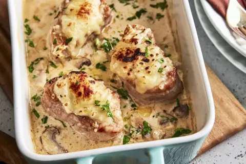 Saftige Medaillons in cremiger Pilzsoße, überbacken mit Käse. Ein köstliches Rezept für den Backofen, garniert mit Petersilie.