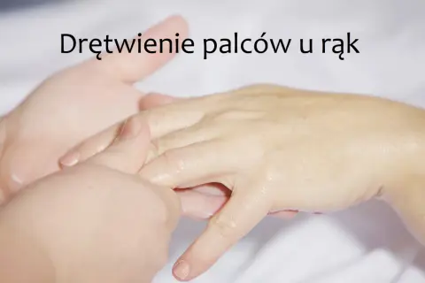 Dłoń masowana w okolicy palców, z widocznym napisem "Drętwienie palców u rąk".