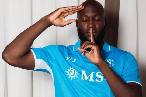 Piłkarz w niebieskiej koszulce Napoli, Romelu Lukaku, robi gest "cisza". Jego waga jest idealna do gry.