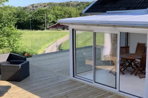 Nybyggd altan med glaspartier och utemöbler. Tänk på att bygga altan utan bygglov kan leda till straff.