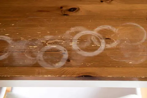 Cercles blancs sur bois : une tache de chaleur laissée par une tasse chaude.