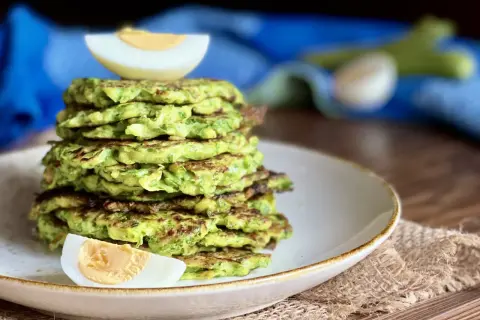 Pila di rosti di zucchine dorati, guarnita con spicchi di uovo sodo. Un piatto leggero e gustoso.