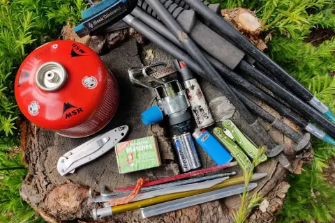 Kijki trekkingowe w bagażu podręcznym: kuchenka gazowa, zapałki, nóż, baterie i śledzie.