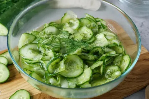 Frischer gurkensalat wie bei Oma, mit Dill garniert, in einer Glasschüssel.