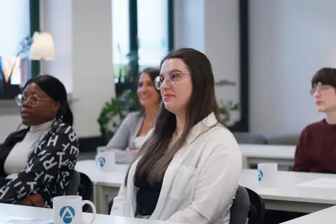 Teilnehmer einer heilpraktiker ausbildung berufsbegleitend lauschen aufmerksam einem Vortrag.