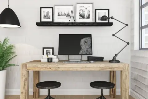 Przytulne biuro z drewnianym biurkiem, monitorem z sową, lampą i rośliną.