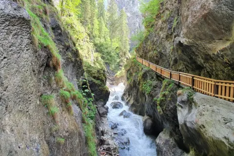 Wilder Wasserfall bei Zell am See, mit Holzsteg entlang der Felswand.