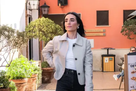 Mujer con chaqueta clara y vaqueros oscuros, lista para un outfit de Semana Santa.