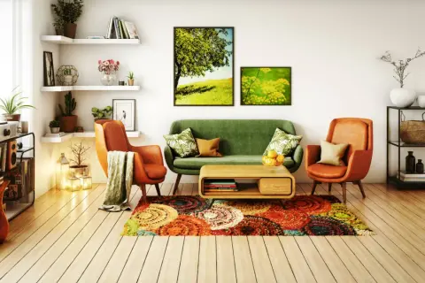 Un salon moderne et chaleureux avec un canapé vert, des fauteuils orange, un tapis coloré et des tableaux de nature. Une belle deco salon.