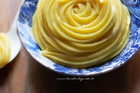 Crema pasticcera senza uova, liscia e vellutata, servita in una ciotola decorata con motivi blu.