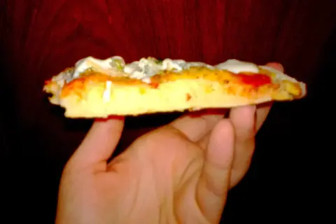 Kawałek puszystej pizzy z serem i sosem, wygląda jak pizza jak z Pizza Hut.
