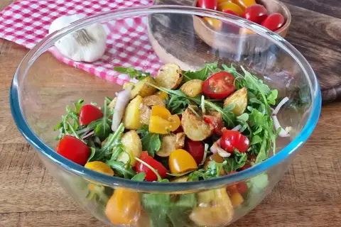 Salade colorée avec pommes de terre rôties, tomates cerises et roquette. Une option légère pour une salade pour maigrir du ventre.