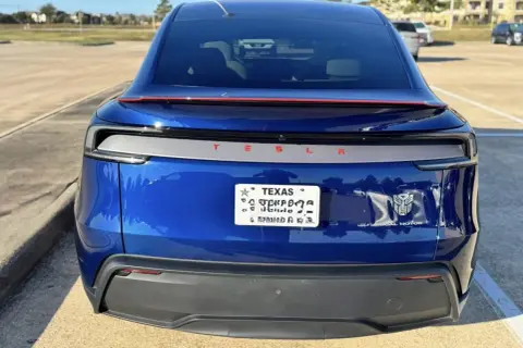 Blå Tesla med registreringsskylt från Texas. En Transformers-logga sitter bredvid "Dual Motor".