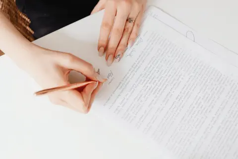 Dłoń pisze na dokumencie, podpisując umowę cfr-1.