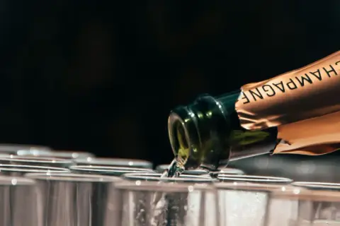 Versando champagne in bicchieri, la temperatura servizio è perfetta per un brindisi.