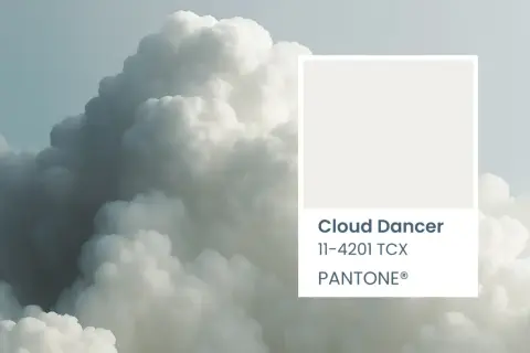 A soft, ethereal cloud formation, reminiscent of a cloud dancer, is paired with the Pantone color swatch for Cloud Dancer 11-4201 TCX.