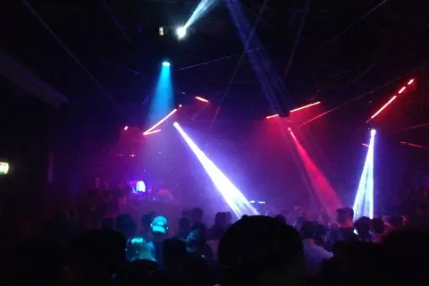 Luci stroboscopiche e fumo in un locale notturno, un'atmosfera da Amnesia Milano recensioni.