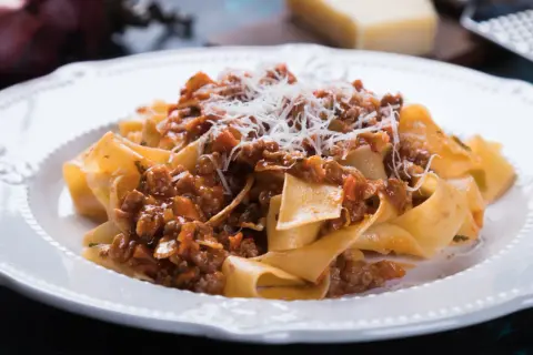 Pappardelle z sosem bolognese, posypane parmezanem. Idealny przepis na spaghetti bolognese oryginalny.