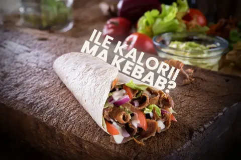 Pyszny kebab na drewnianej desce, z napisem "Ile kalorii ma kebab?".