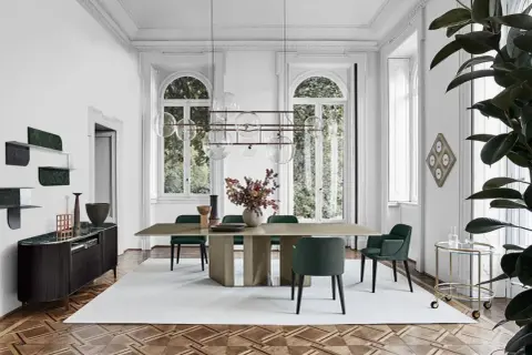 Sala da pranzo con tavolo e sedie in stile mid century modern, illuminata da un lampadario a sfere e con un mobile basso in legno scuro.