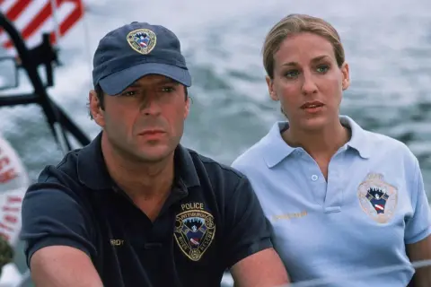 Bruce Willis w filmie "Sześć dni, siedem nocy" jako ratownik wodny. Obok niego Sarah Jessica Parker.