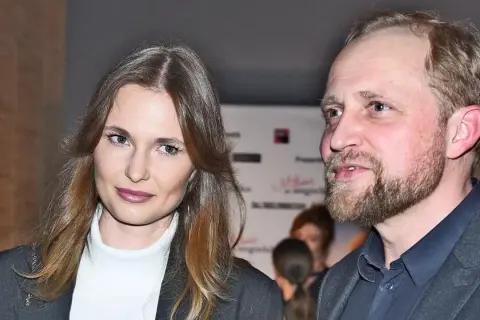 Piotr Adamczyk z żoną, uśmiechnięci, pozują do zdjęcia.