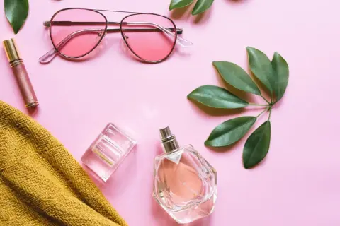 Różowe okulary, błyszczyk, żółty sweter i dwa flakony perfum – być może najpiękniejsze perfumy świata.