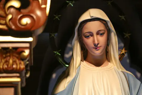 Figurka Matki Boskiej z błękitnymi oczami i aureolą gwiazd. Zastanawiamy się, ile lat żyła Maryja, gdy patrzymy na jej spokojną twarz.