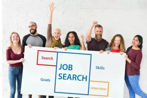 Grupa ludzi trzyma tablicę z napisem "JOB SEARCH", symbolizującą poszukiwanie pracy i najbardziej poszukiwane zawody w Polsce.