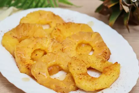 Rodajas de piña a la plancha, doradas y jugosas, espolvoreadas con canela. Un postre tropical irresistible.