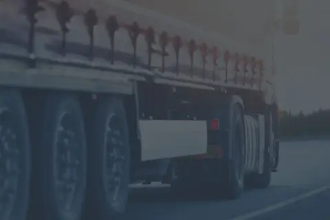 Ciężarówka w ruchu drogowym, przygotowana do testów na przewóz rzeczy. Widok na koła i naczepę.