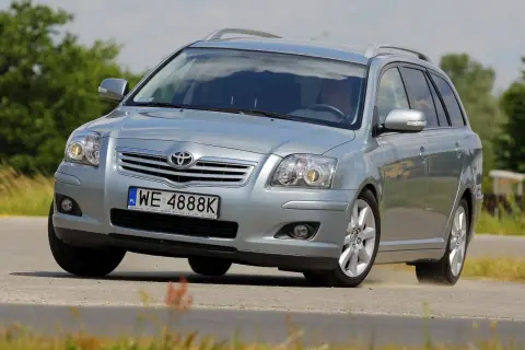 Srebrny kombi Toyota Avensis T25 z polskimi tablicami WE 4888K pokonuje zakręt na drodze, unosząc lekki pył.