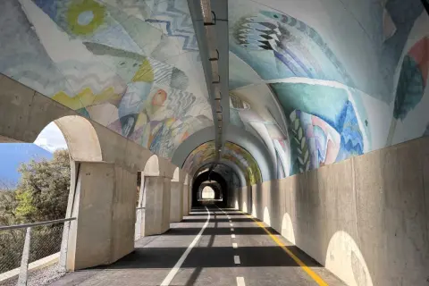 Ciclabile Riva del Garda: un tunnel artistico con affreschi colorati sul soffitto e un percorso ben segnalato.