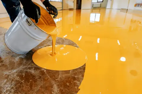 Aplicando resina epoxi amarilla en un suelo. El proceso de como aplicar resina epoxi en suelos es sencillo.