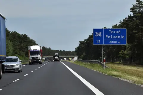 Droga ekspresowa S12 w kierunku Toruń Południe. W oddali widać wiadukt i inne pojazdy.