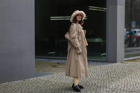 Eleganckie loafersy damskie dopełniają stylizację z beżowym płaszczem i futrzaną czapką.